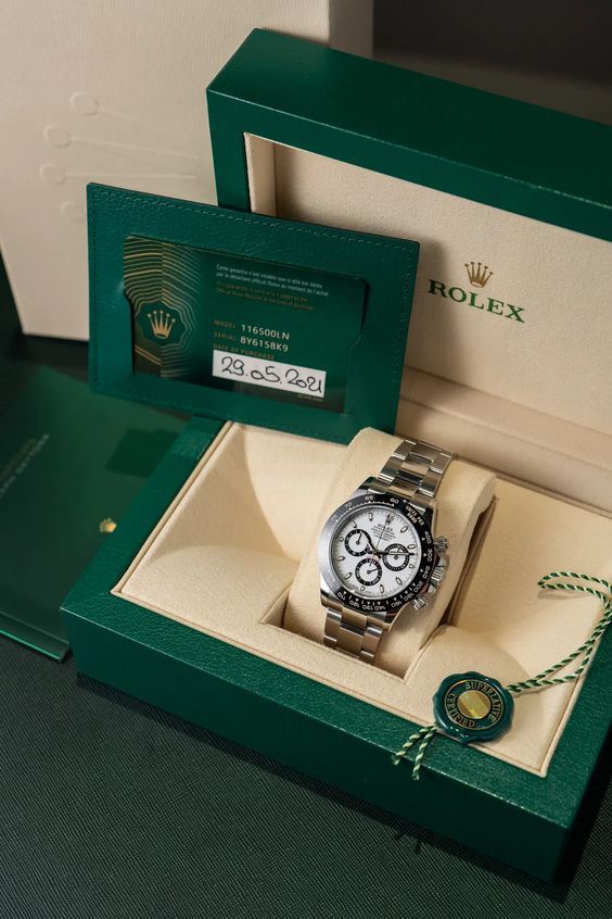 Rolex watch in a green box with a card and tag.